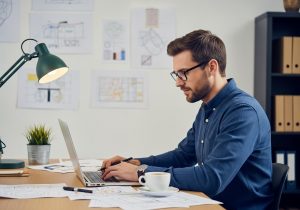 Designer arbeitet fokussiert an einer Website während einer intensiven einwöchigen Designphase am Schreibtisch.